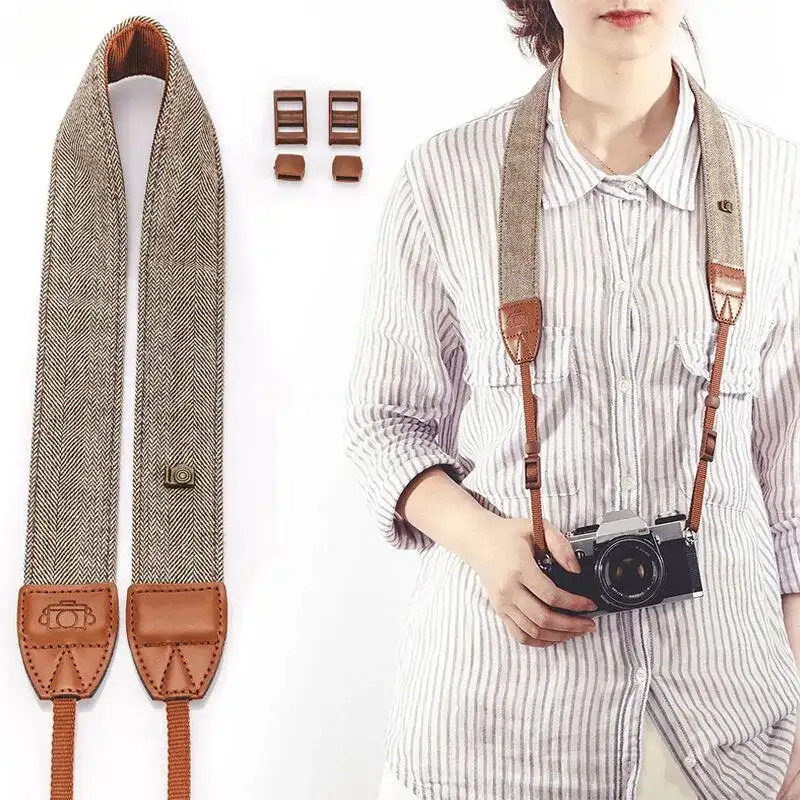 The cotton and leather strap laid flat beside a woman wearing it with a film camera resting at her waist