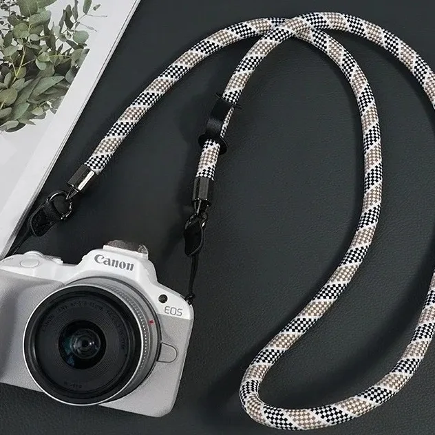 Red braided rope strap attached to a silver rangefinder camera with black quick-release fittings at both lugs